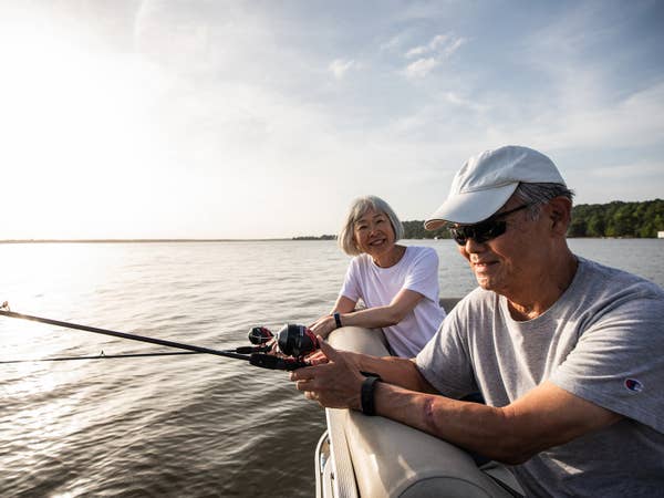 Two adults fishing off of a pontoon boat at Villages Resort in Flint, Texas.