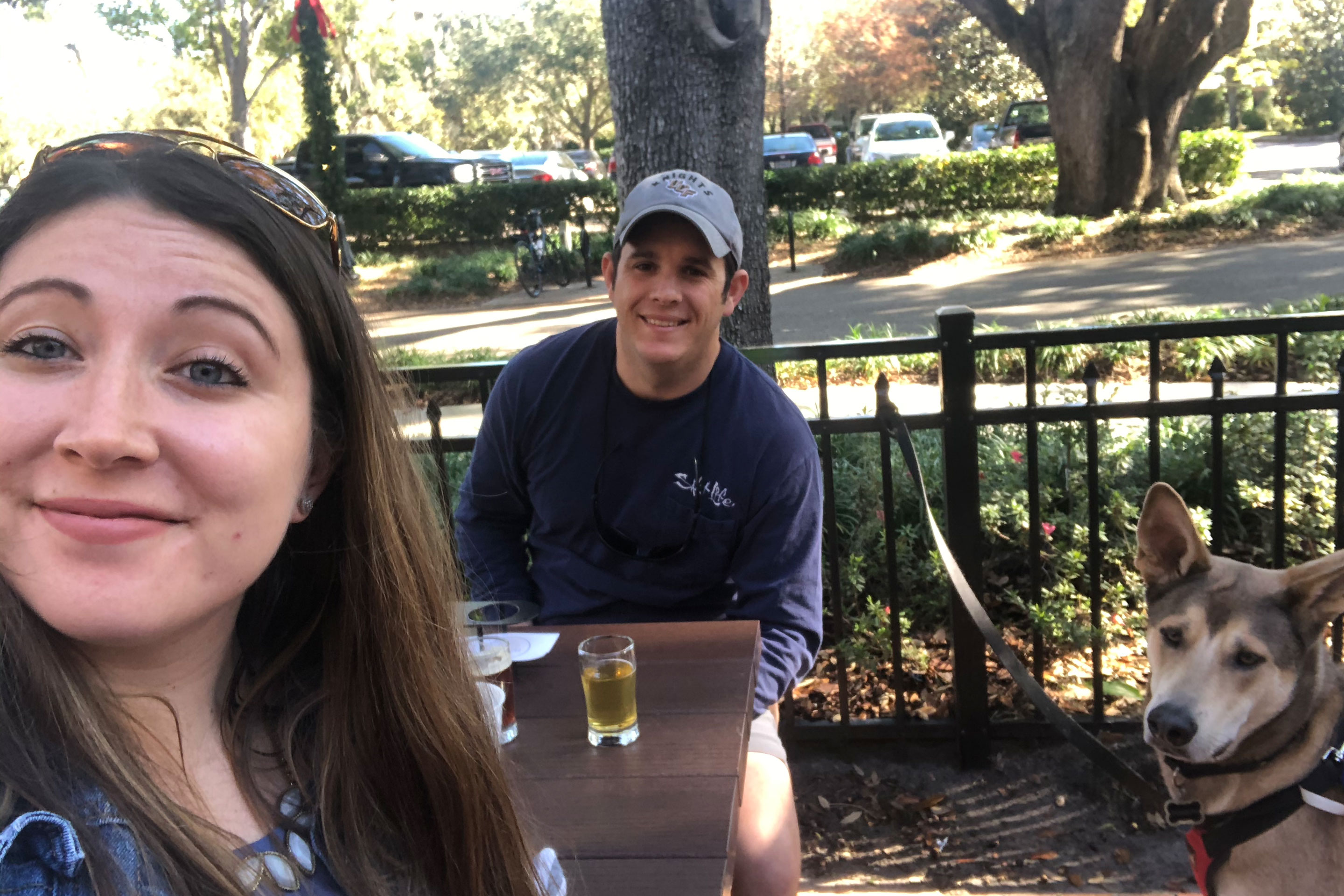 Featured Contributor and Checking In Editor, Tori Ferrante (left), and husband, Books (middle), enjoy a cold beer outside of 'Hourglass Brewing Co.' with their dog, Deagon (right).