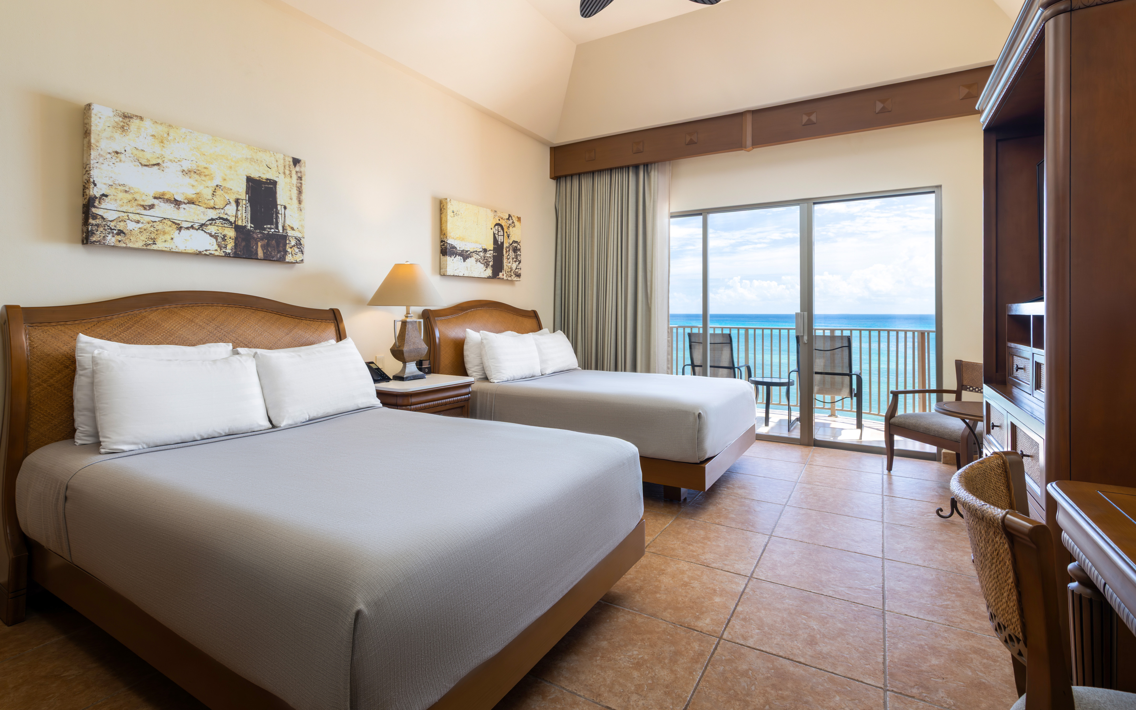 Oceanview bedroom with balcony and two comfortable beds.