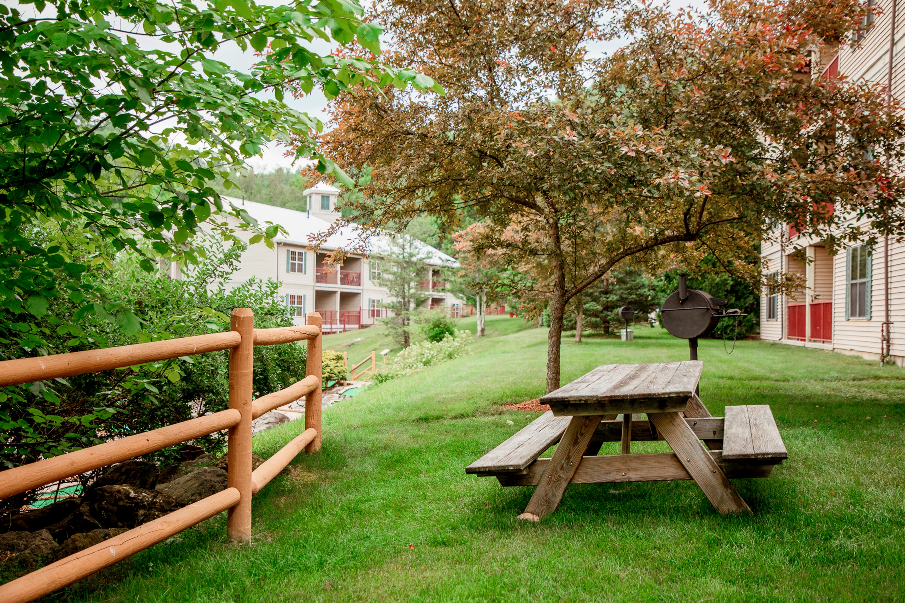 A beautiful shot of an Oak n' Spruce Resort building with lush greenery in the foreground