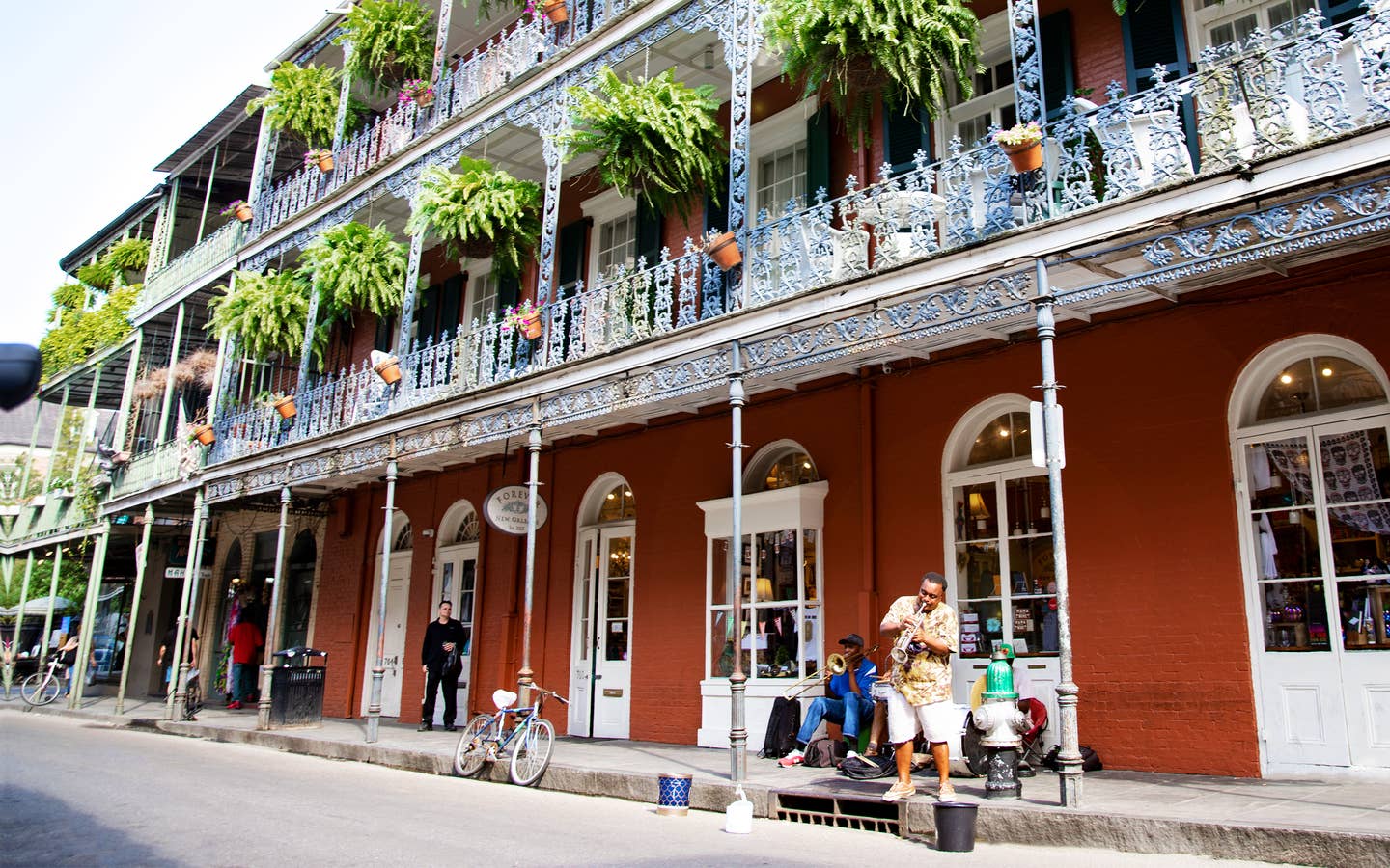 Bourbon Street under a sunny blue sky with street performers near New Orleans Resort.