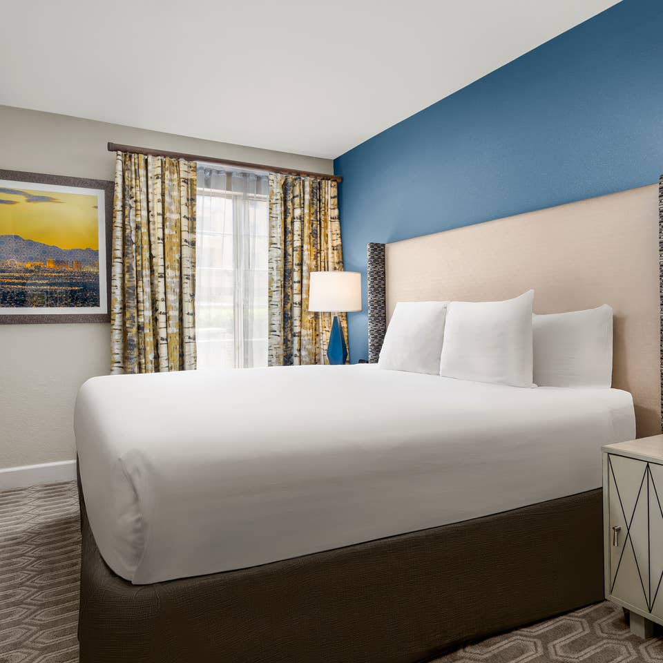 Bright bedroom with modern decor and blue accent wall.