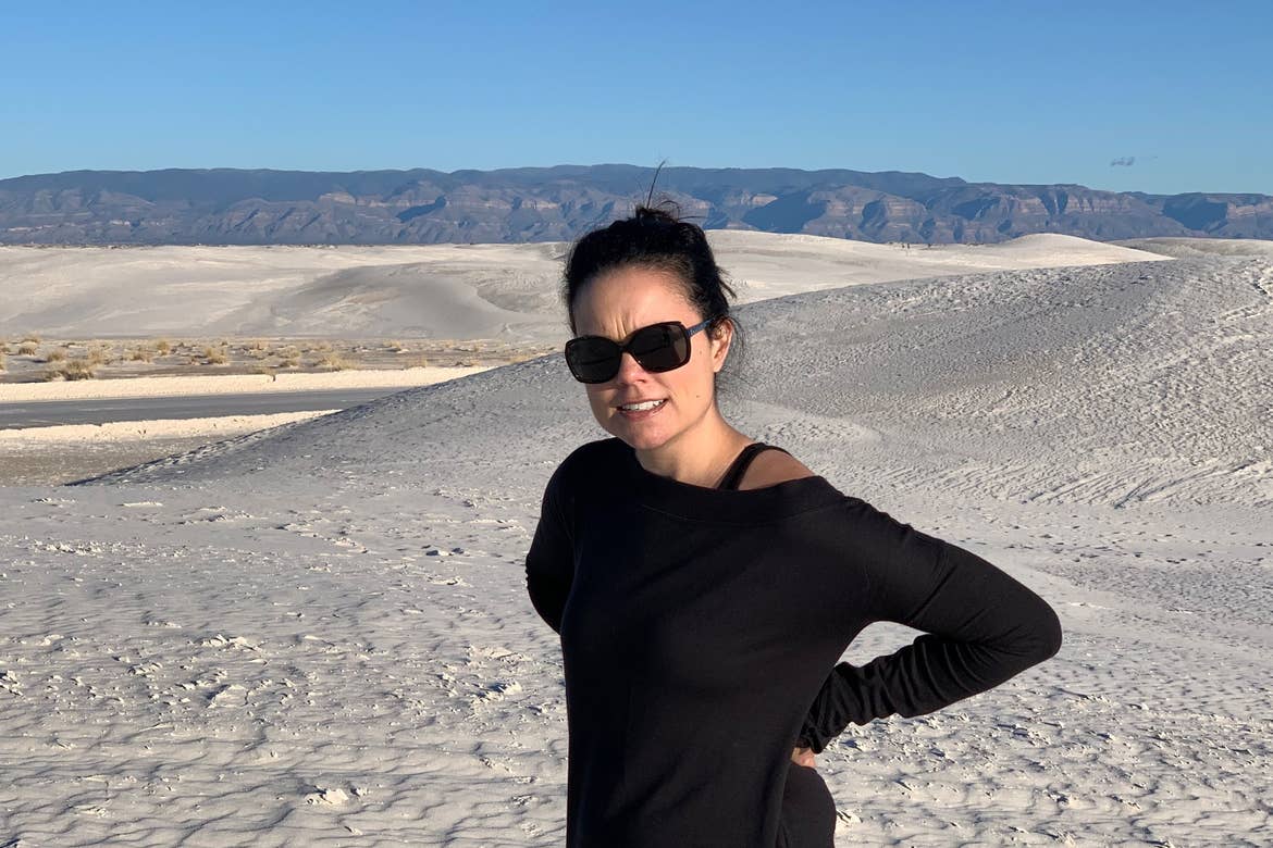 Author, Lauren Layne, stands looking frustrated at the White Sands National Monument.