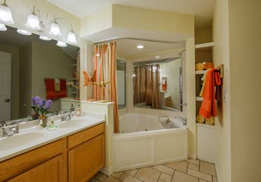 Bathroom with two-sink vanity and garden tub in a two-bedroom presidential villa at the Holiday Hills Resort in Branson Missouri.