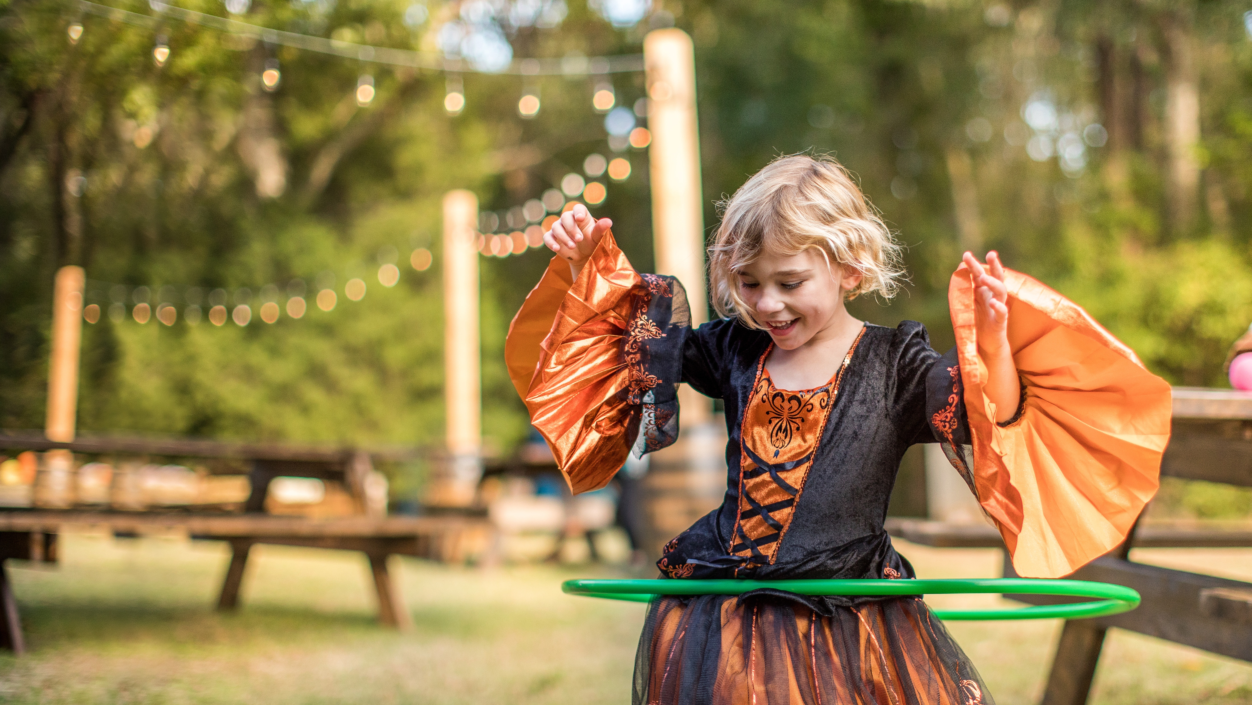 Child hula-hooping in a Halloween costume.