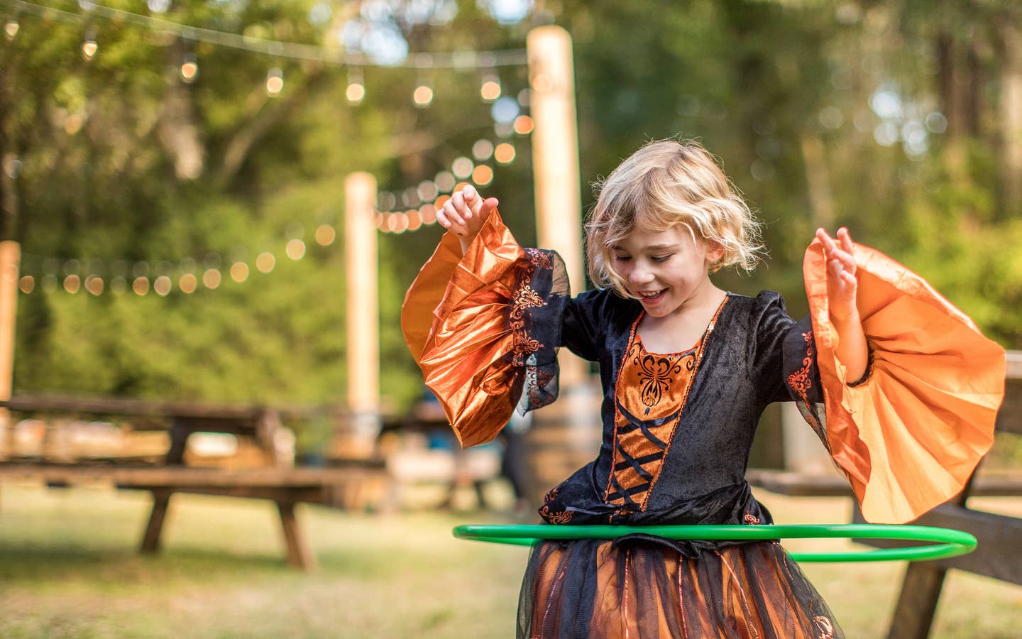 Child hula-hooping in a Halloween costume.