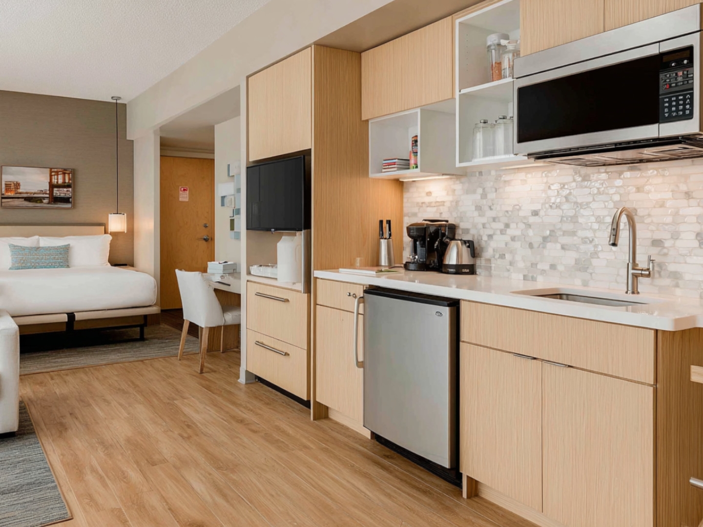Stylish and bright hotel room offering spacious living area and kitchenette with modern amenities.