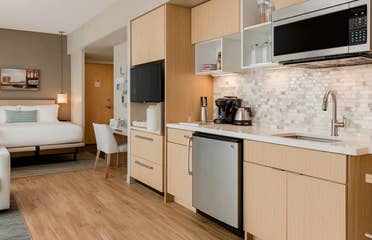 Stylish and bright hotel room offering spacious living area and kitchenette with modern amenities.