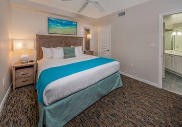 Bedroom with attached bathroom and coastal decor in a one-bedroom villa at Panama City Beach Resort