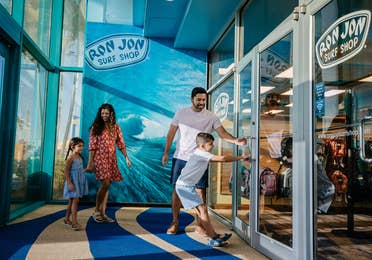 Family of four walking into Ron Jon Surf Shop near Cape Canaveral Beach Resort in Florida.