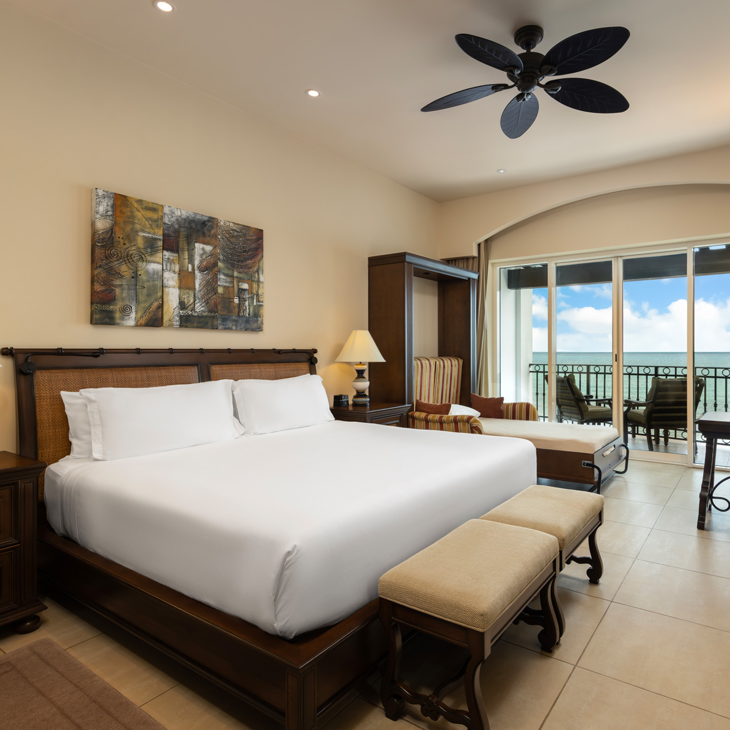 Oceanview king bedroom with seating area, daybed, and balcony.