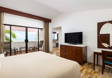 Oceanview villa bedroom with two beds and balcony access.