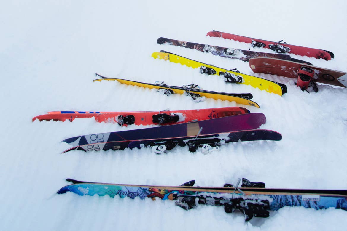 Several sets of skis sit in the snow.