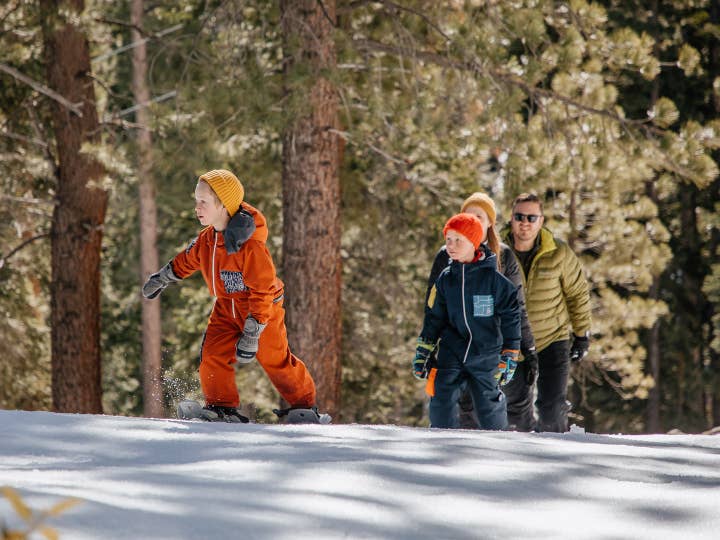 Family of four skiing on snowy hill near Tahoe Ridge Resort in Stateline, Nevada.