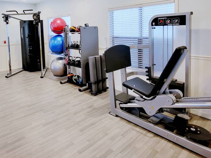 Fitness Center with yoga matts, weights, resistance bands, and leg press machine at Holiday Hills Resort in Branson, Missouri.