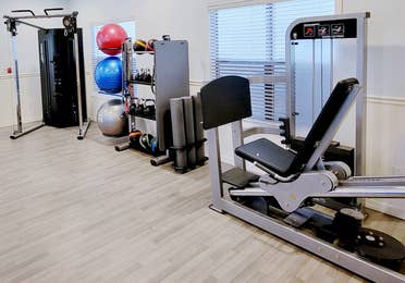Fitness Center with yoga matts, weights, resistance bands, and leg press machine at Holiday Hills Resort in Branson, Missouri.