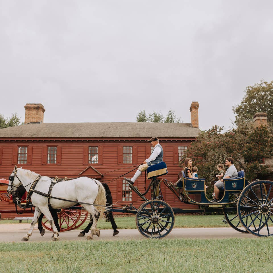 Family taking ride on horse-drawn carriage in Williamsburg, Virginia near Williamsburg Resort.