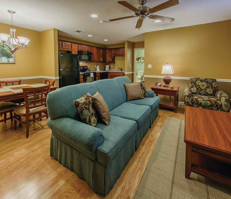 Living room couch with dining area in the background of a one-bedroom ambassador villa at the Hill Country Resort in Canyon Lake, Texas.
