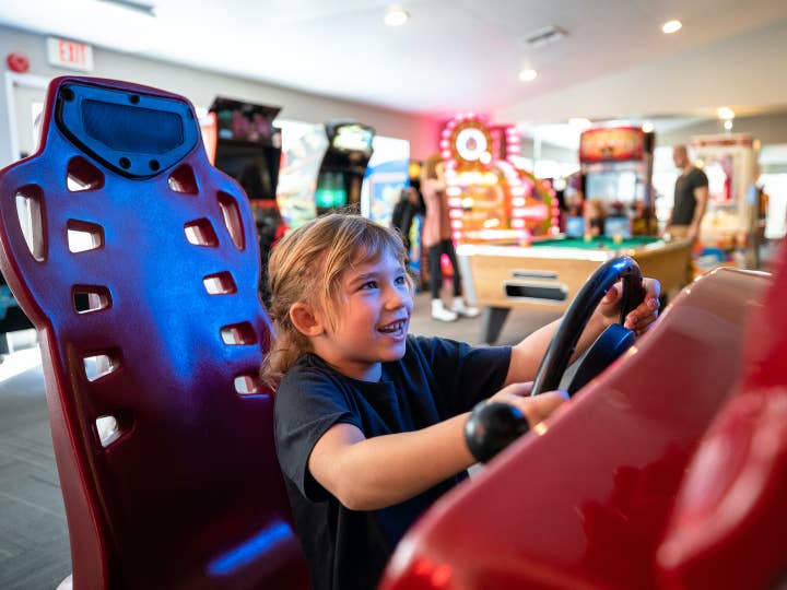 Young child playing arcade racing game at Desert Club Resort in Las Vegas, Nevada