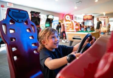 Young child playing arcade racing game at Desert Club Resort in Las Vegas, Nevada