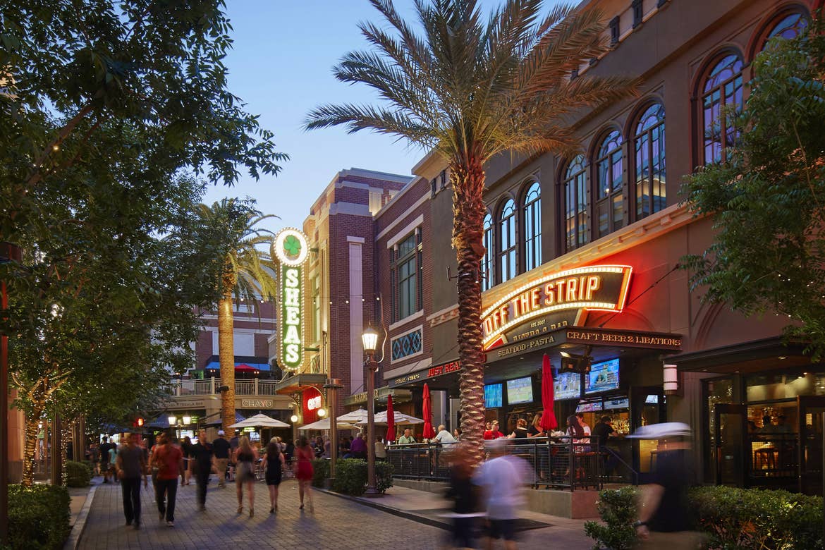 Several people walk near building exteriors of restaurants and shops on Las Vegas Fremont Street.