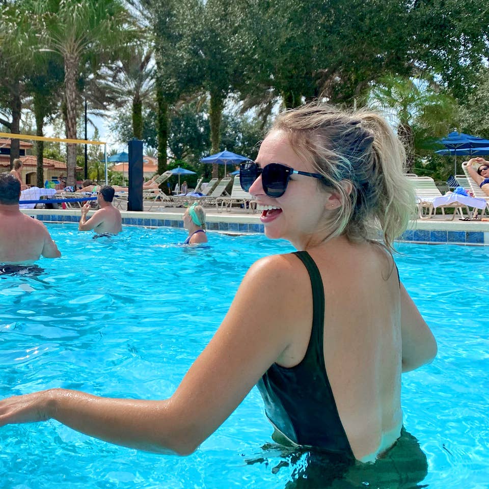 Featured Contributor, Angie Orth, wears a black swimsuit in the pool at our Orange Lake Resort in Orlando, Florida.