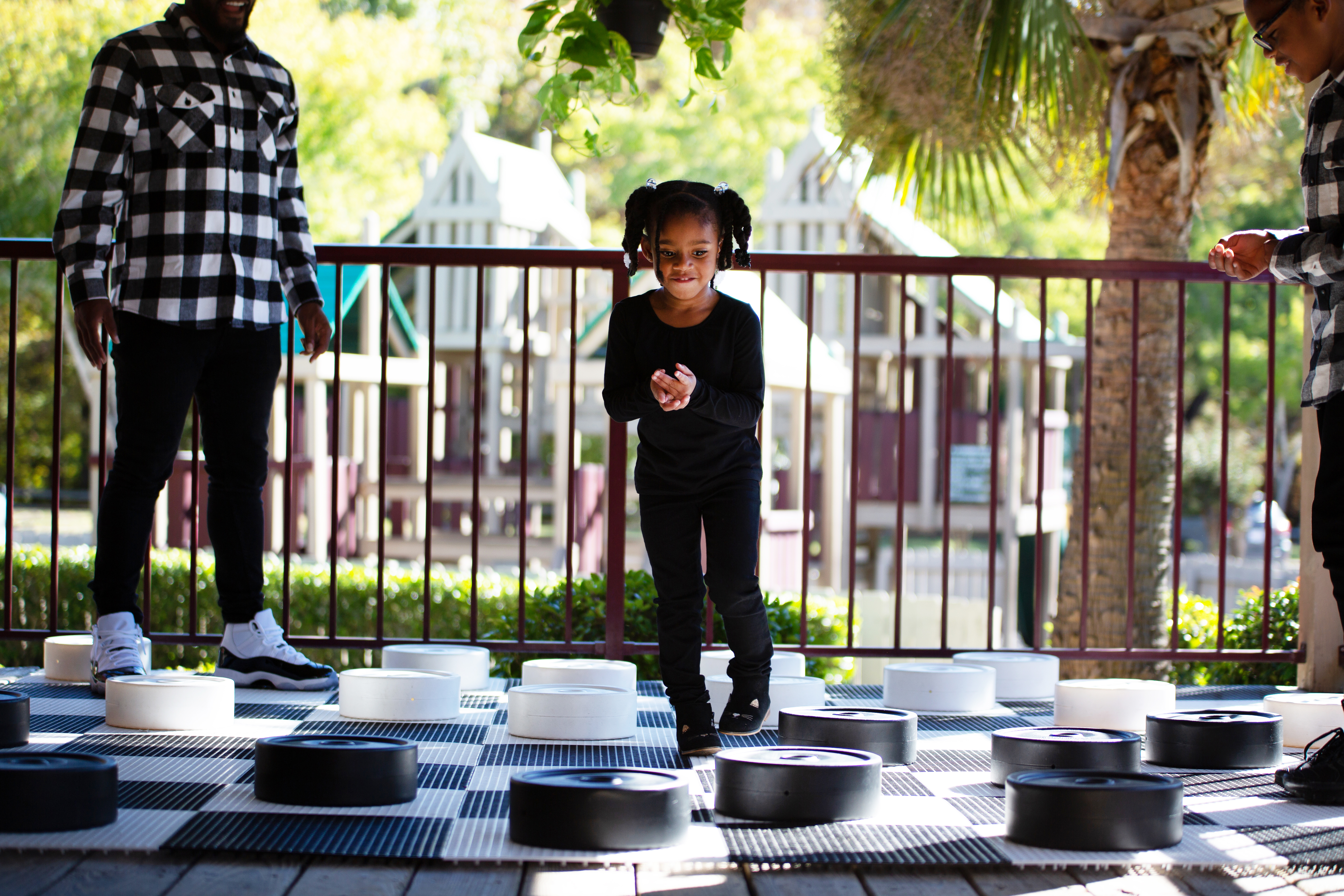 Toddler playing a jumbo-sized game of checkers.