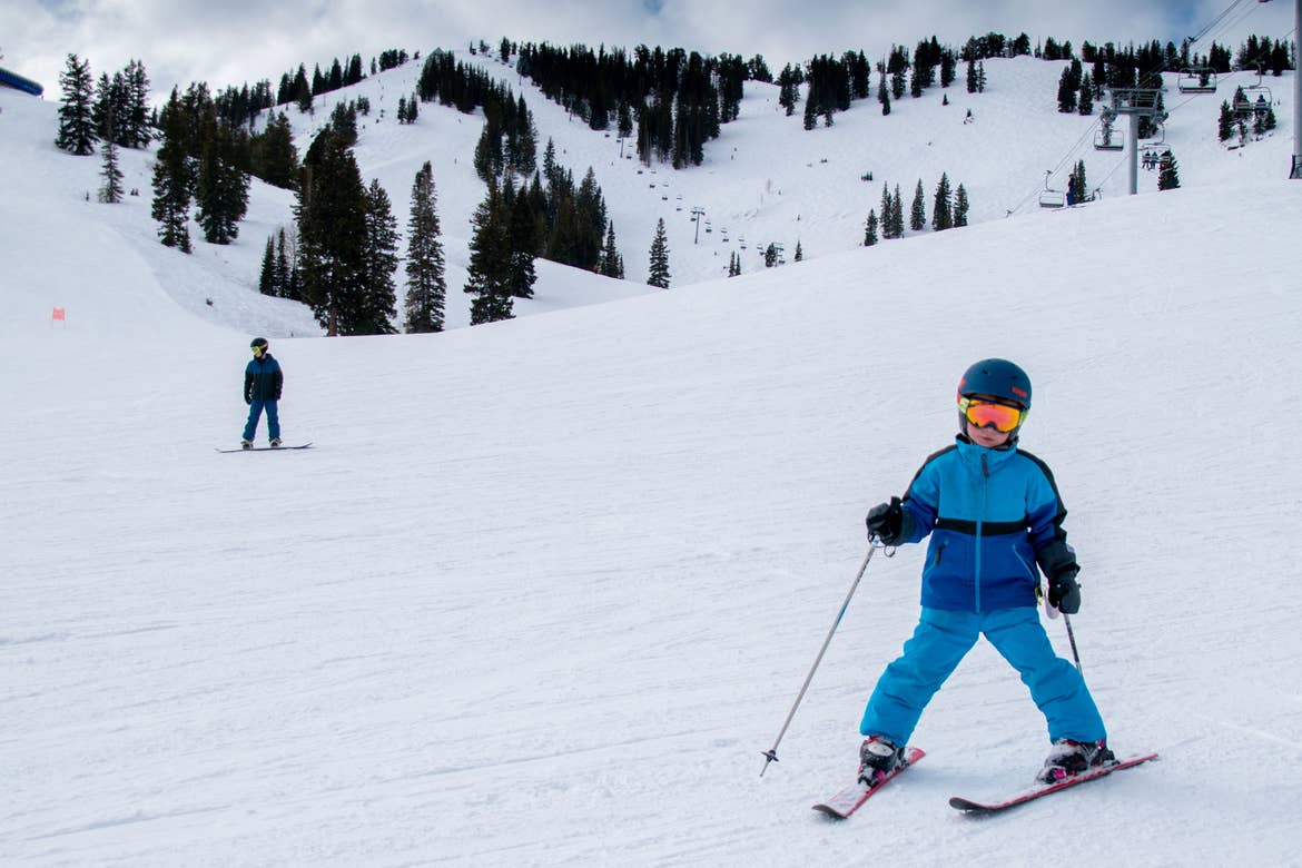 Jessica's son clad in winter and skiing gear ascends from the trail.