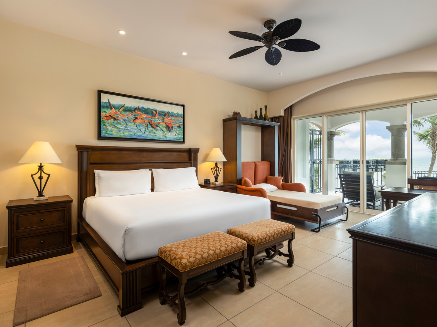 Suite bedroom with king bed, daybed, and ocean views.