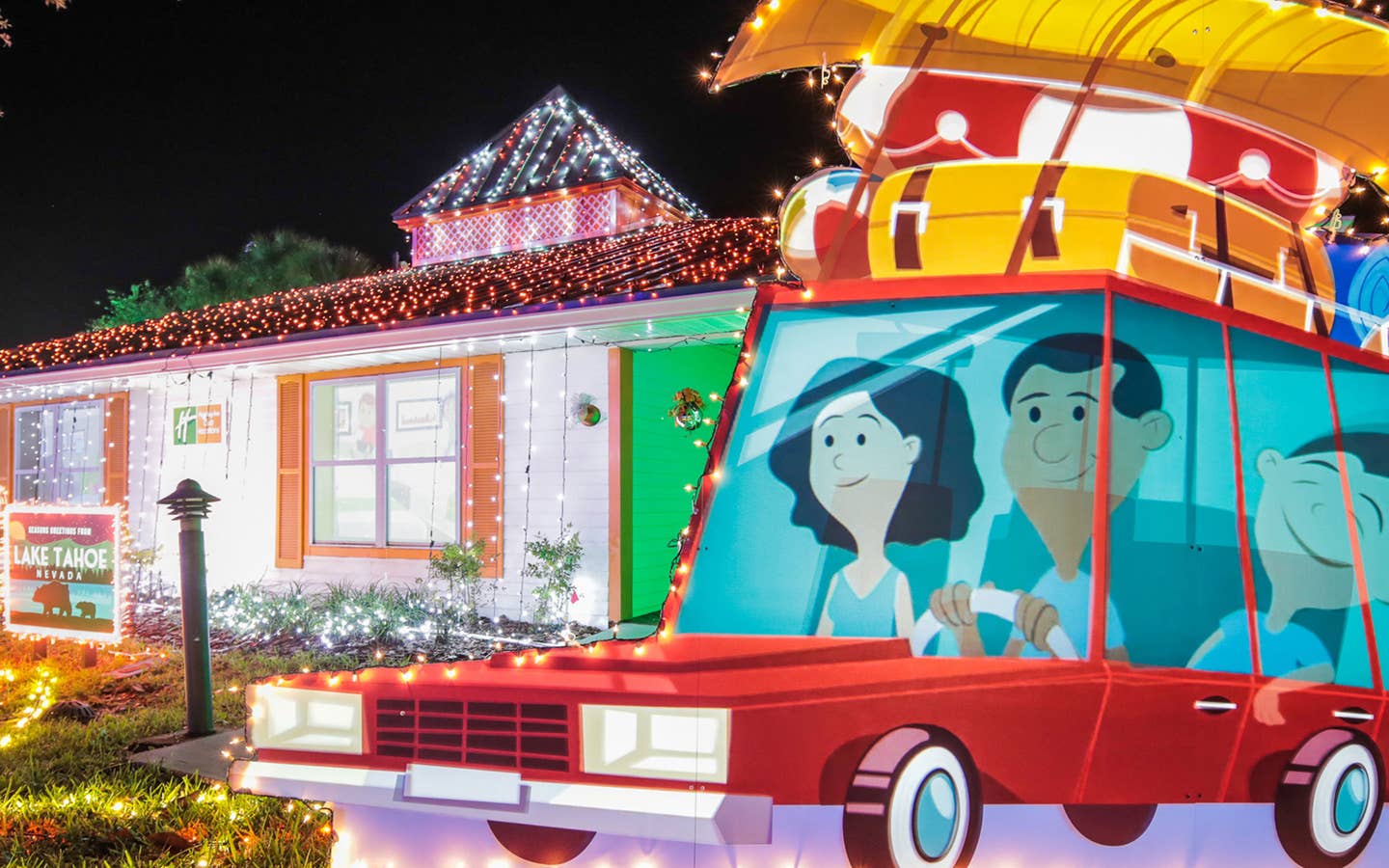 An exterior shot of our HICV villa decorated for the 'Night of a Million Lights' event complete with oversized travel postcards and a family station wagon.