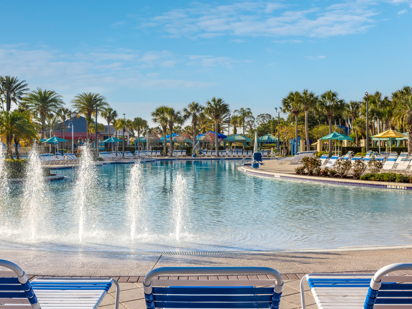 Zero-entry pool surrounded by palm trees in West Village at Orange Lake Resort near Orlando, Florida.