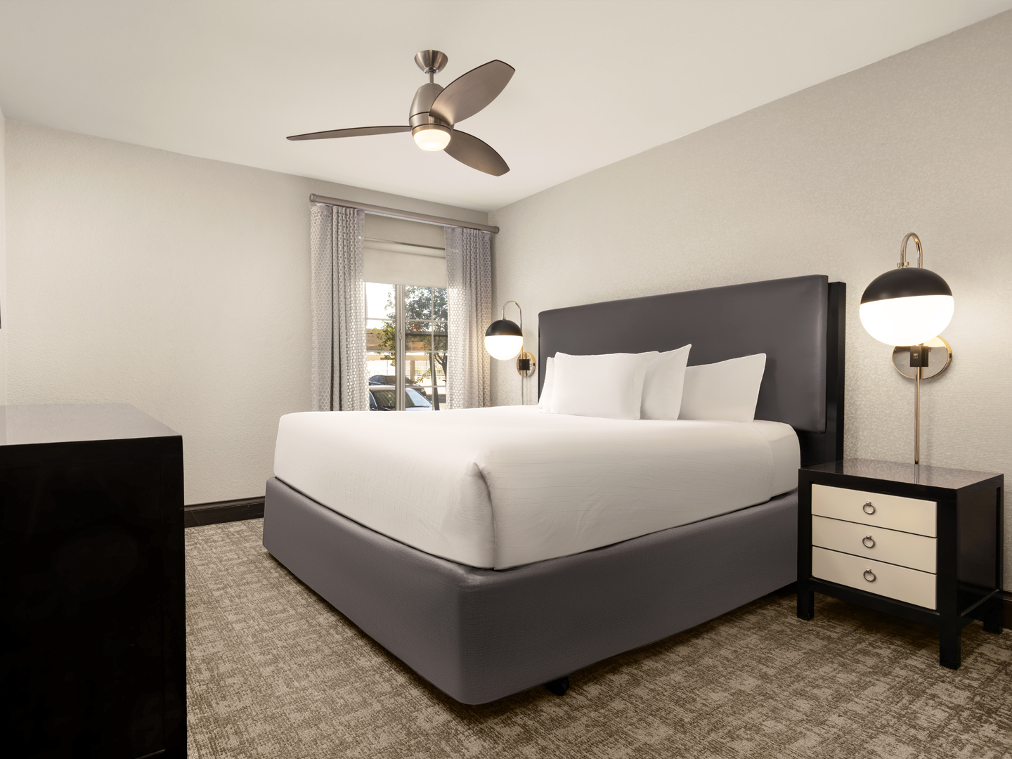 Contemporary bedroom with plush bedding and modern lighting.
