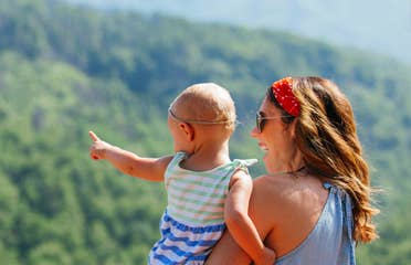 A mother hods her daughter while overlooking the Great Smoky Mountains.