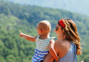 A mother hods her daughter while overlooking the Great Smoky Mountains.