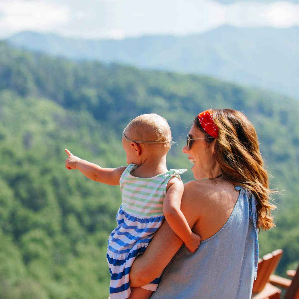 A mother hods her daughter while overlooking the Great Smoky Mountains.