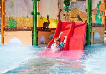 Child going down waterslide in Splash Canyon water feature at Scottsdale Resort.