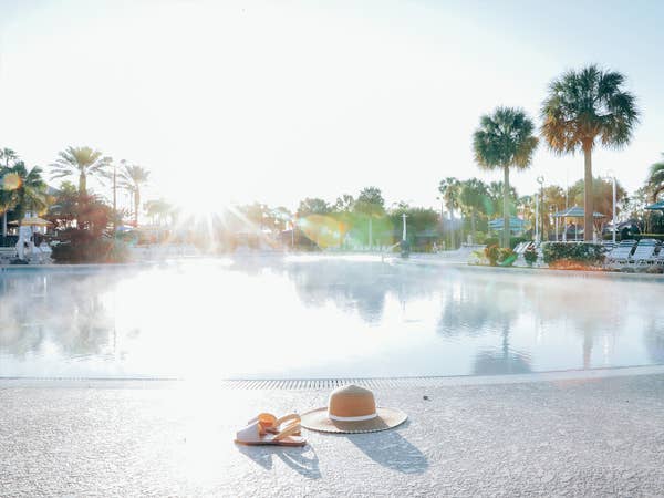 Sunhat and sandals sitting in front of pool at Orange Lake Resort near Orlando, Florida.