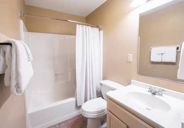 Bathroom with shower/tub combination and sink in a two-bedroom lodge villa at Fox River Resort in Sheridan, Illinois.