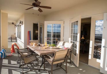 Furnished balcony with ceiling fans and a table with six chairs in a four bedroom Signature villa in River Island at Orange Lake Resort near Orlando, Florida