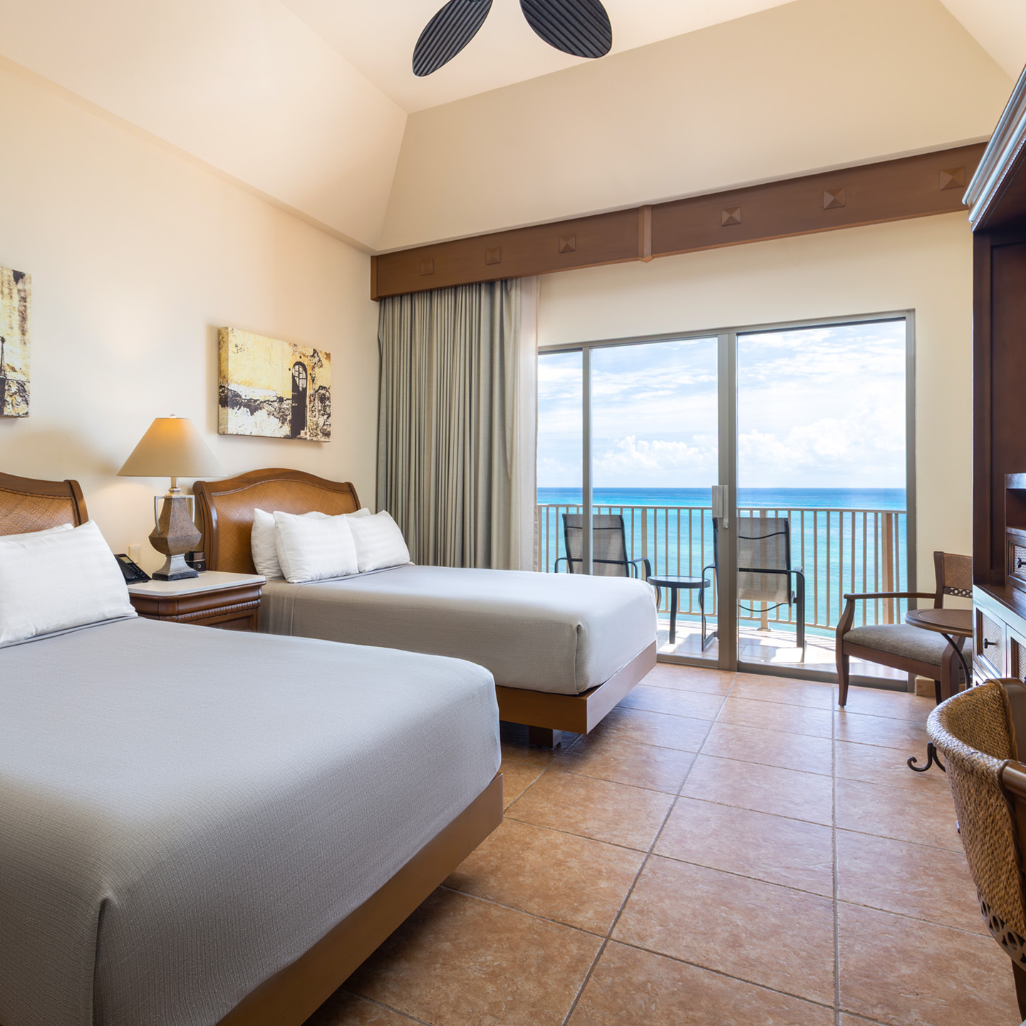 Oceanview bedroom with balcony and two comfortable beds.