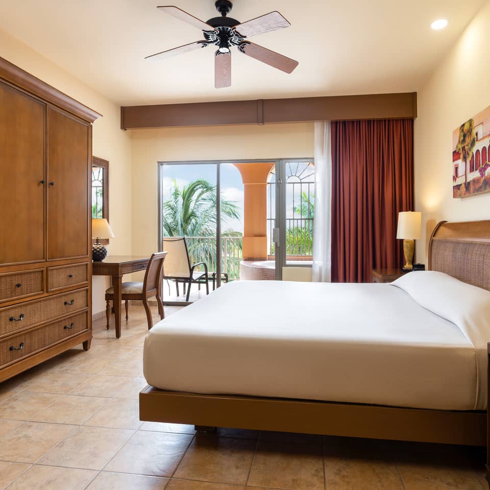 Large garden-view bedroom opening to a balcony with soaking tub.