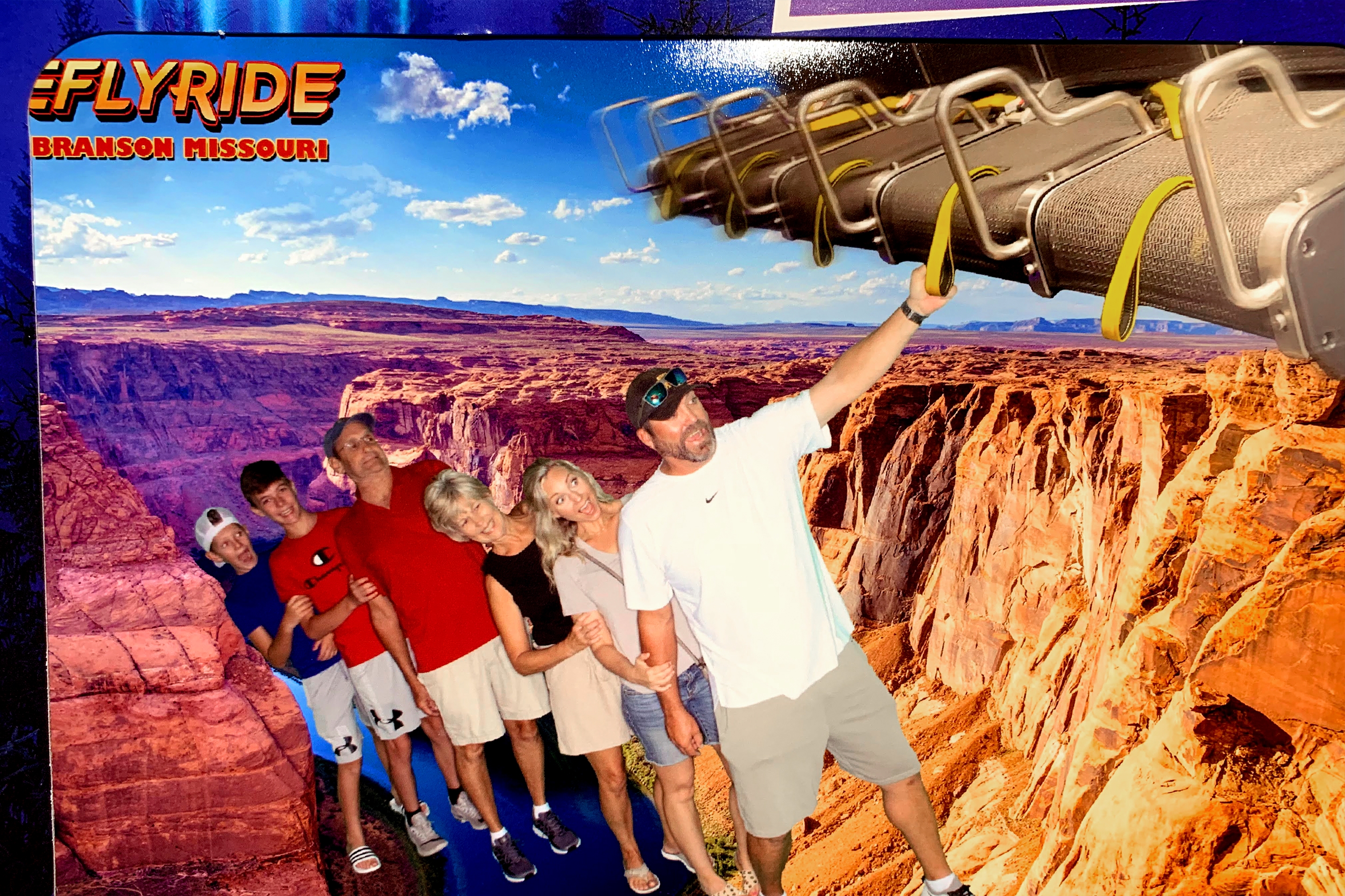 Two men, two boys and two women take a 'greenscreen' photo overlooking the Grand Canyon.
