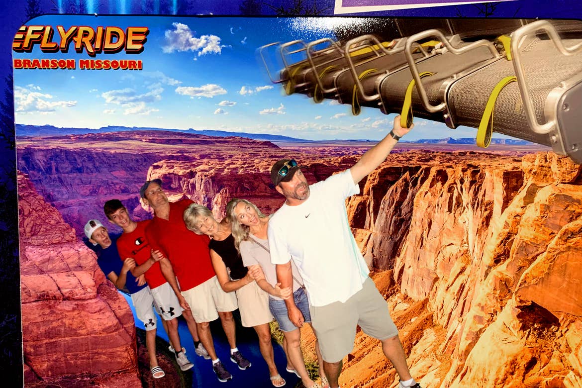 Two men, two boys and two women take a 'greenscreen' photo overlooking the Grand Canyon.