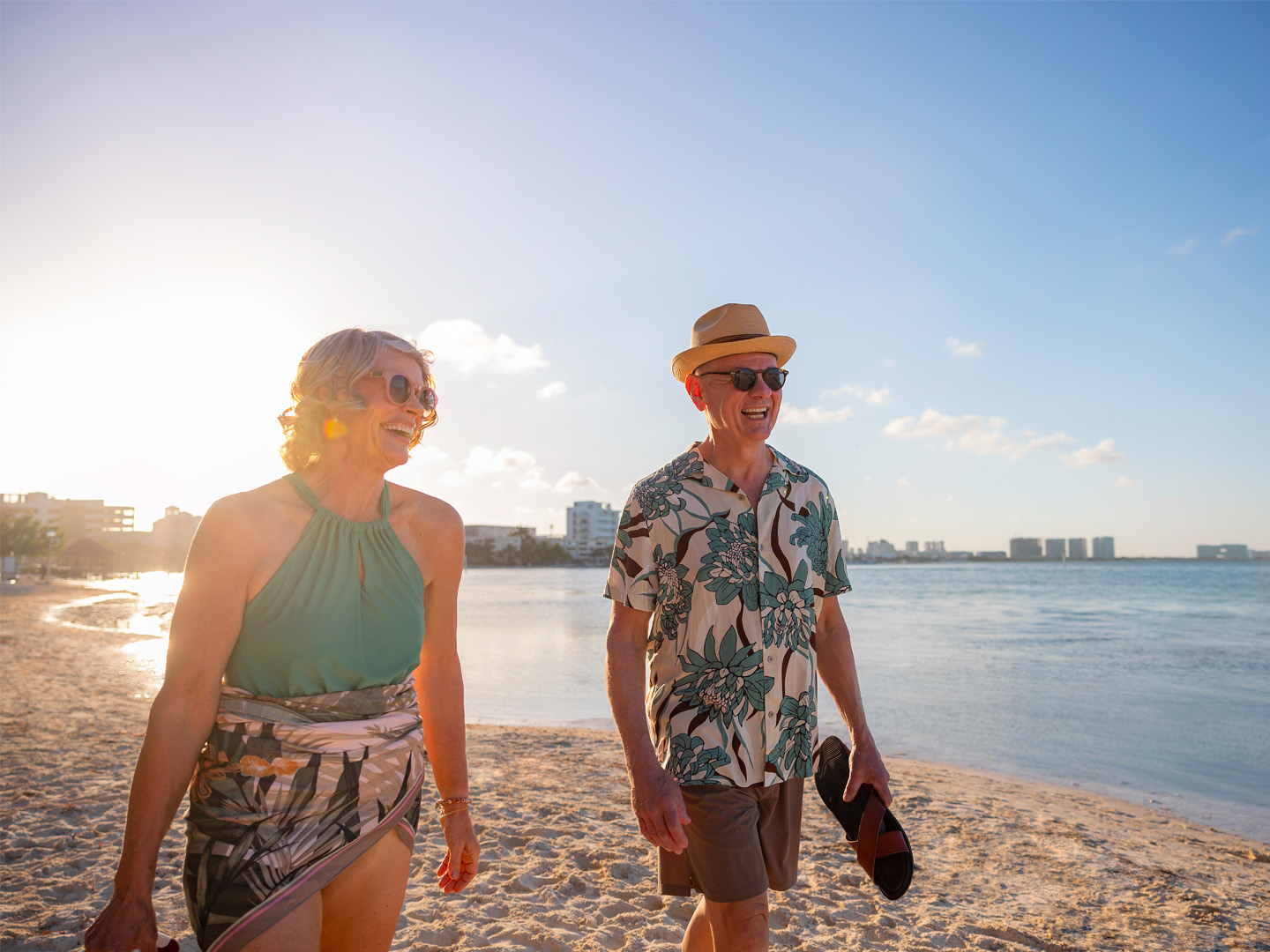 Couple walking on the beach at sunset.