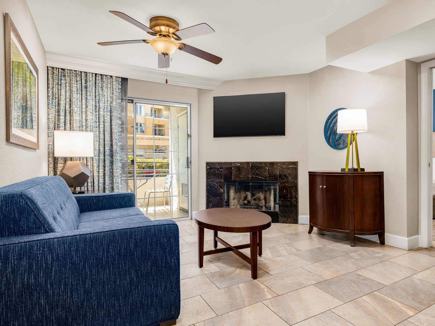 Living room with sofa, fireplace, and access to private balcony.
