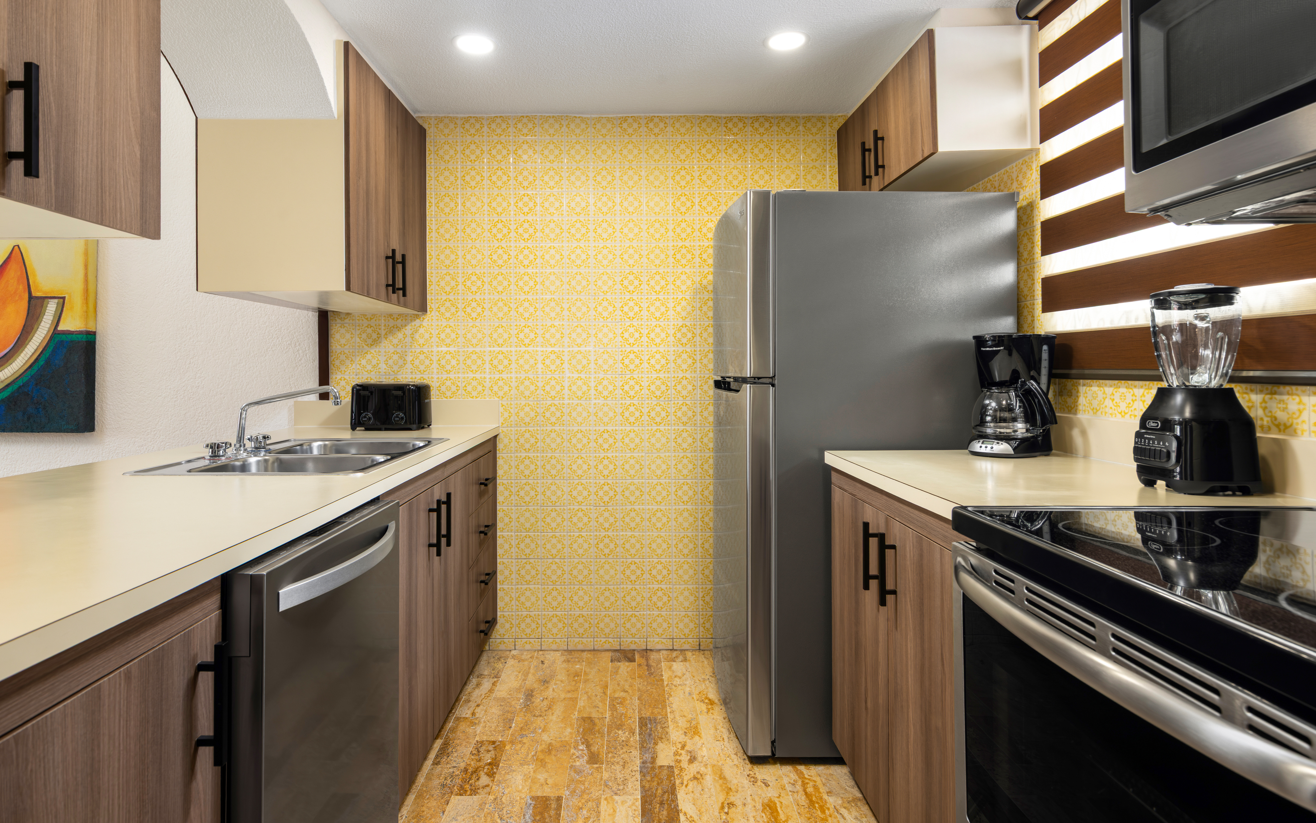 Bright villa kitchen with stove, fridge, and cabinets.