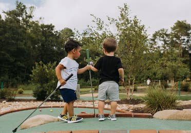 Two young children playing mini golf at Williamsburg Resort.