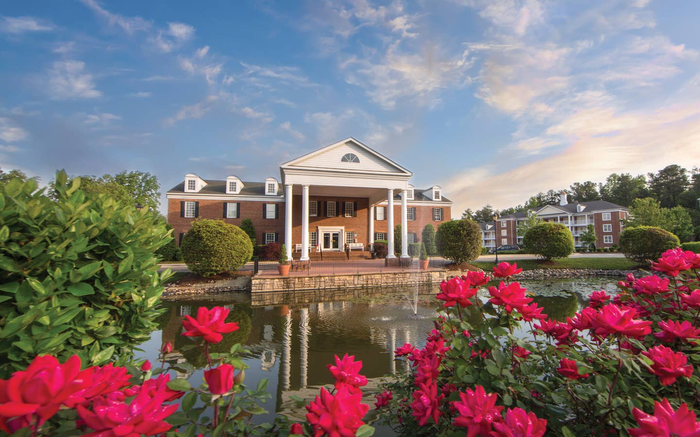 Property building surrounded by pink flowers at Williamsburg Resort in Virginia.