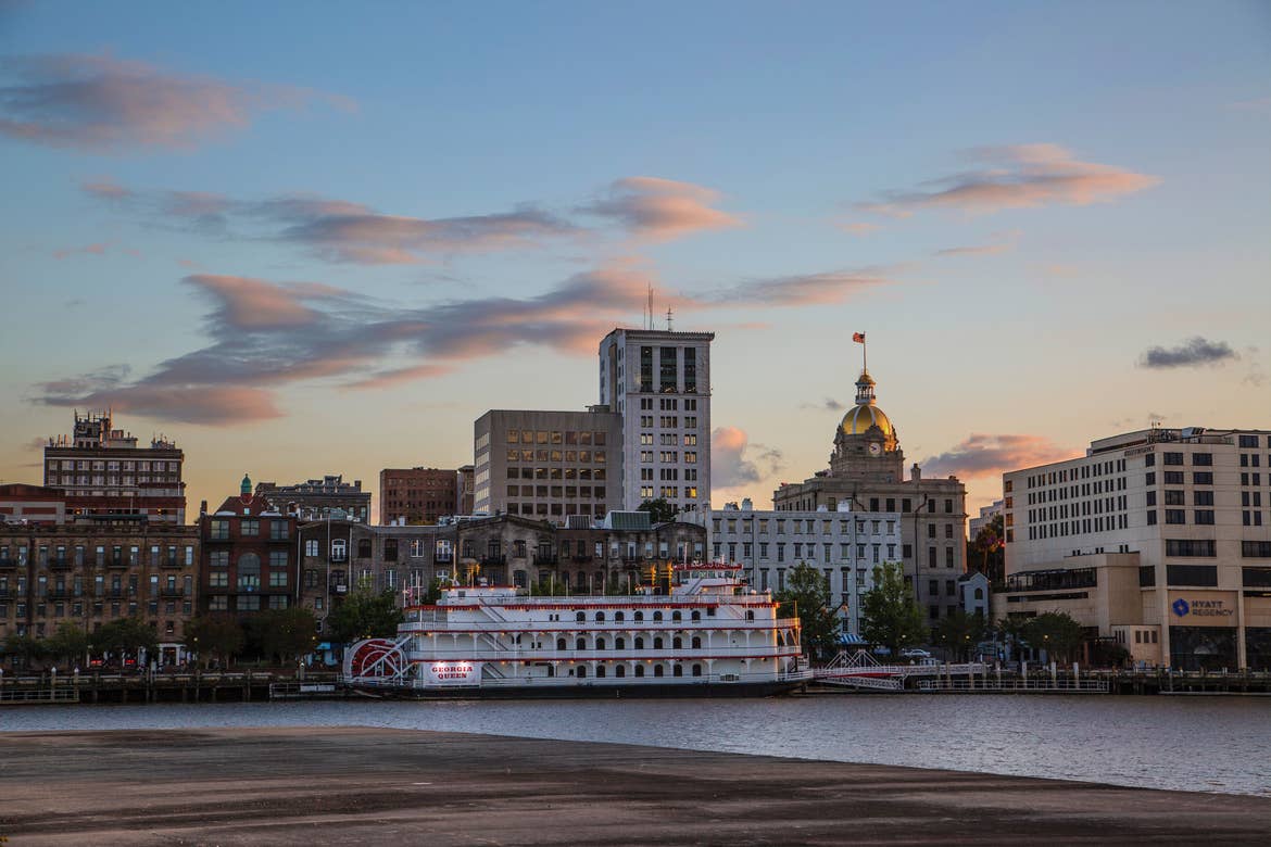 A view of the 'Georgia Queen' on the Mississippi River in Savannah, GA surrounded by historical architecture.