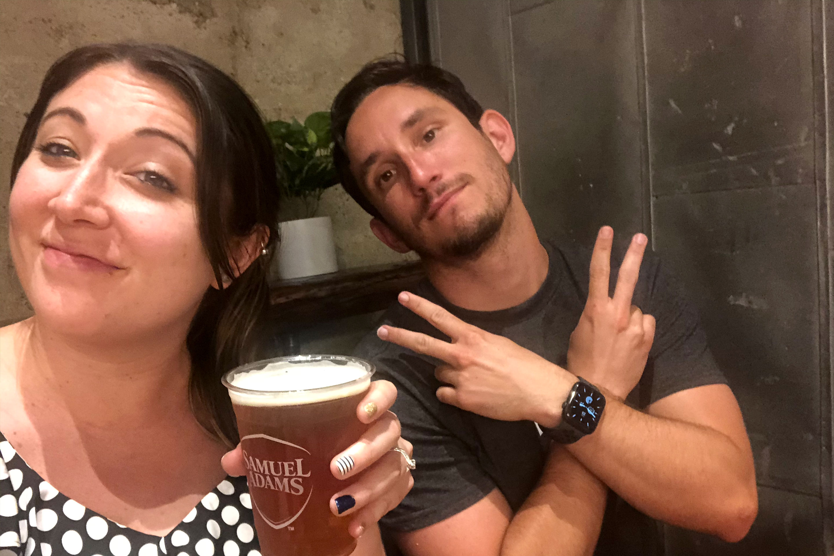 A woman (left) holds a beer and a man (right) sits next to her.